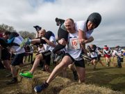 Men bearing their “wives” in the Carry the Wife Competition