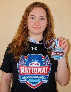 Beachburg’s Katie Comeau sports her national championship t-shirt and shows the medal she earned as a member of the Liberty Lady Flames university hockey team.