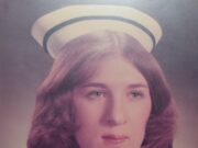 Obituary – Nancy Gayle Felhaber a brunette woman in a white hat with a blue stripe around it, with white skin and a white nurse's uniform.